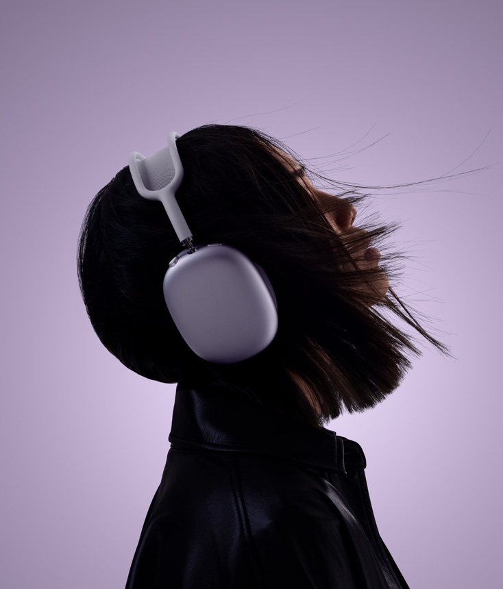 Perfil de uma pessoa usando fones de ouvido AirPods Max 2 na cor roxa com a cabeça levemente inclinada para cima