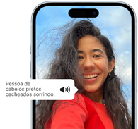 iPhone 15 mostrando o recurso Voiceover falando as informações da imagem, Uma pessoa com cabelo preto ondulado sorrindo