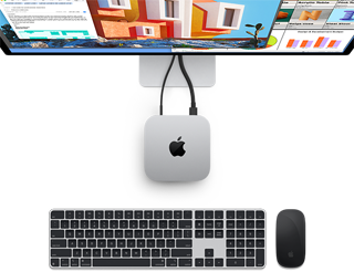 Parte superior do Mac mini prateado com logotipo da Apple, conectado a um monitor e ao lado de um Magic Keyboard e Magic Mouse sem fio.