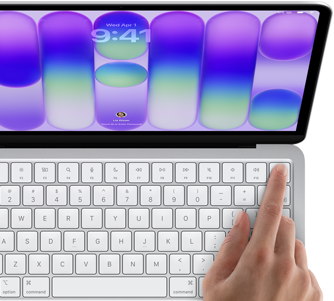 MacBook Neo prateado mostrando a tela de início de sessão, com o dedo de uma pessoa no sensor do Touch ID no canto superior direito do teclado