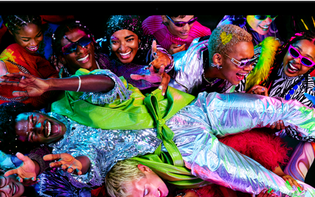 A tela colorida de um MacBook Pro mostra uma pessoa passando por cima de uma multidão em uma festa, destacando a tela Liquid Retina XDR em cores vibrantes