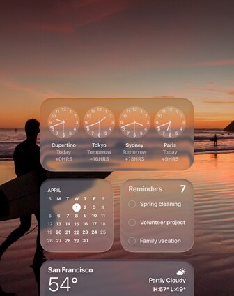 Widgets de Relógio, Calendário, Lembretes e Tempo em Liquid Glass na tela do macOS Tahoe sobre uma cena de um surfista caminhando na praia ao pôr do sol